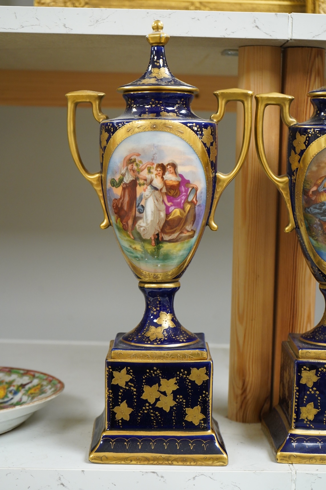 A pair of early 20th century Vienna style porcelain urns and covers, 36cm